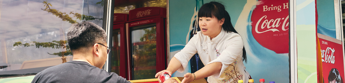 A woman in Nanjin China serves a Coca-Cola